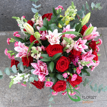 Red rose and pink lily flower arrangement in vase
